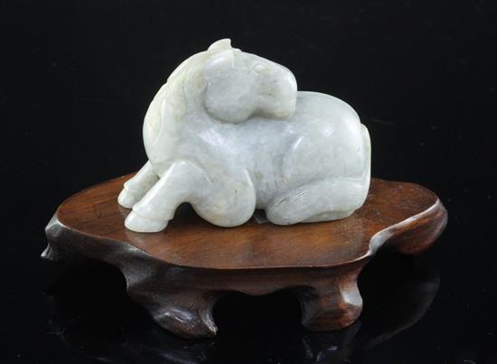 A Chinese mottled pale grey jade figure of a recumbent horse, probably Ming dynasty, 7.2cm, wood stand